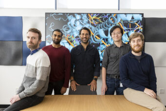 Five scientists from Evercrisp in a conference room in front of a screen with a protein structure