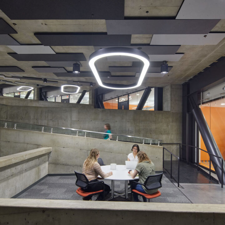 Three people sitting at a table underneath an oval fluorescent light